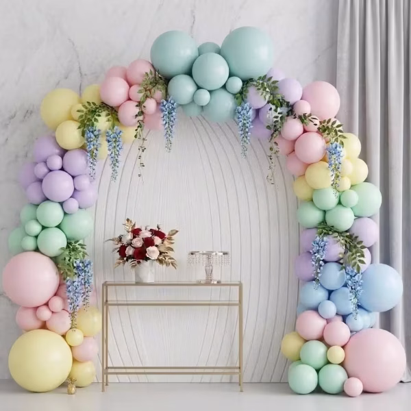 Arcada din baloane asamblata in culori pastelate macarons cu baloane jumbo si accente asimetrice prezentata intr un decor de eveniment festiv