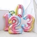 balon folie cifra curcubeu 100 cm Set de baloane din folie metalizata in forma de cifre de la 0 la 9, in nuante pastelate de curcubeu gradient, cu dimensiunea gigant de 100 cm.