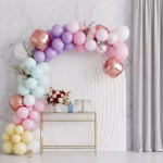 Arcada din baloane asamblata in culori pastelate roz pudra bleu mov verde galben si sfere din folie rose gold prezentata intr un decor elegant