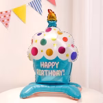 Balon din folie 3D standing in forma de briosa cu baza albastra mesaj Happy Birthday crema alba cu buline colorate si o lumanare aprinsa in varf