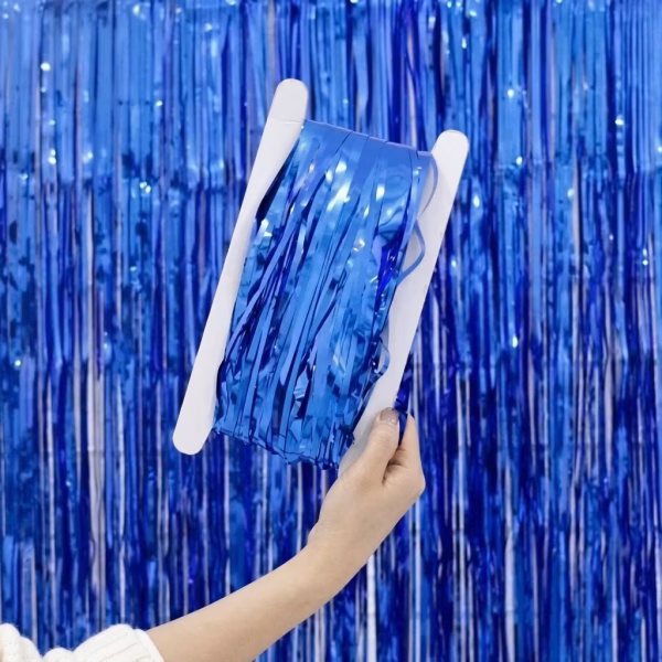 Perdea decorativa din franjuri tip tinsel realizata din folie metalizata de culoare albastra infasurata partial pe un suport din carton alb