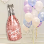 Balon din folie metalizata in forma de sticla de sampanie de culoare roz pudrat decorat cu buline aurii inimioare albe si mesajul central Cheers avand gatul sticlei argintiu