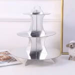 suport etajat pentru prajituri argintiu Suport etajat pentru prajituri argintiu din carton, cu 3 niveluri, asezat elegant pe o masa de petrecere alaturi de decoratiuni.