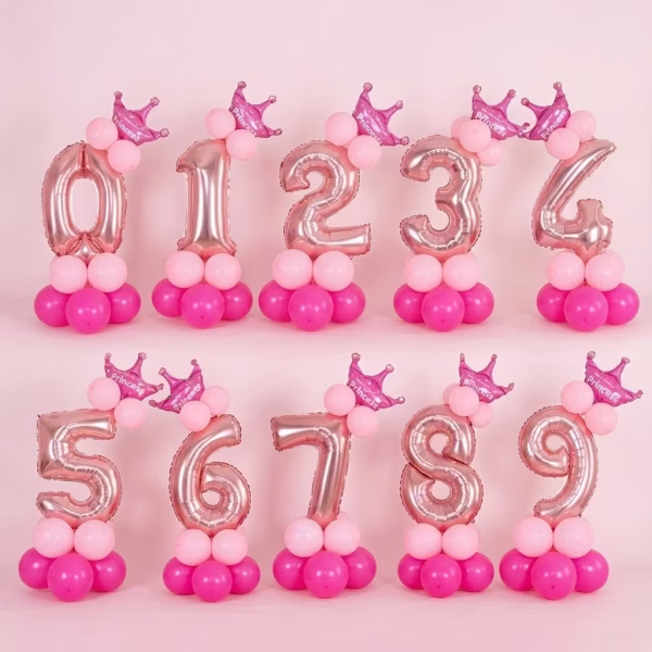 Aranjament Baloane Cifra Rose Gold Prezentarea completa a seturilor de 14 baloane cu cifrele de la 0 la 9, ilustrand nuanta rose gold, coronitele de printesa si baza din latex roz.