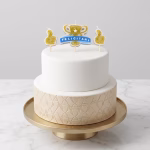 Tort etajat elegant decorat in alb si bej cu un set de trei lumanari aurii reprezentand un trofeu cu mesajul Felicitari incadrat de doua semne Like