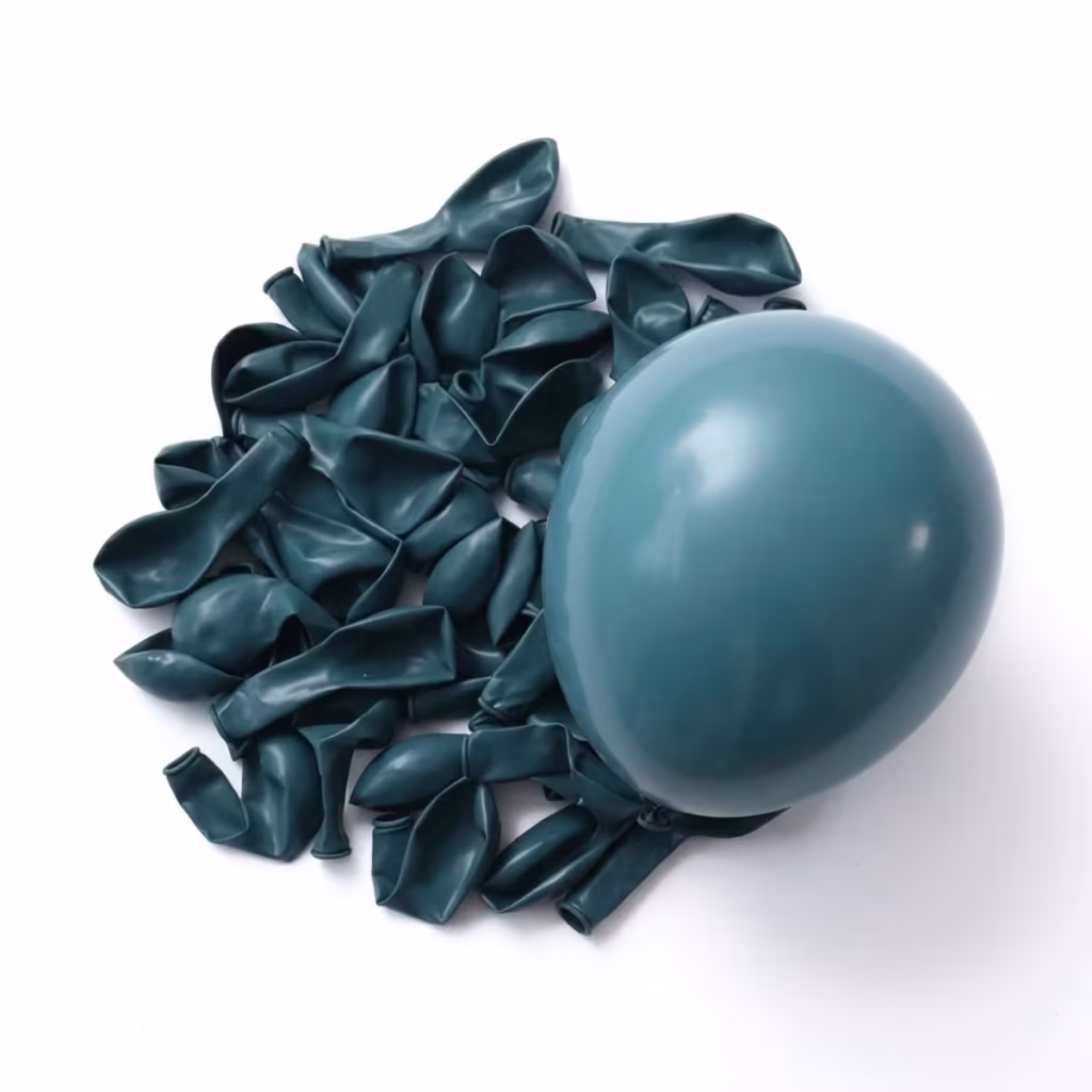 Un balon rotund din latex umflat, având o nuanță mată și elegantă de albastru prăfuit (dusty blue), așezat deasupra unei grămezi de baloane neumflate din aceeași culoare, pe un fundal alb neutru