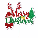 Topper pentru tort din carton decupat pe contur, ilustrând mesajul Merry Christmas cu o textură ce imită sclipiciul roșu și verde, decorat creativ cu coarne de ren, o căciulă de Moș Crăciun, o fundiță roșie, clopoței aurii și un brad verde de Crăciun