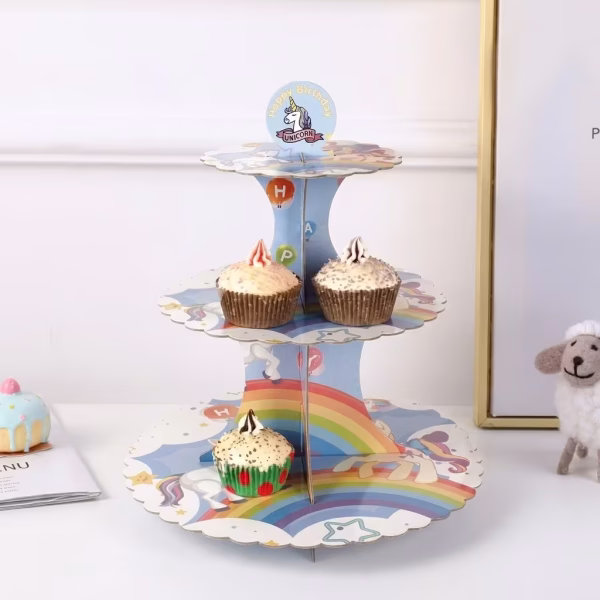 Suport Etajat Pentru Prajituri Curcubeu Unicorni Suport etajat pentru prajituri din carton, cu tematica unicorn si curcubeu, avand 3 niveluri decorate, folosit frecvent pentru constructia torturilor din dulciuri la gradinita.