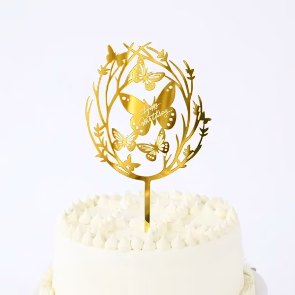 topper tort happy birthday auriu Topper decorativ pentru tort, mesaj Happy Birthday, culoare auriu oglindat, material plexiglass premium. Design elegant ce ilustreaza o coronita din ramuri delicate si fluturi.