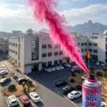 Spray pentru gender reveal cu ambalaj neutru decorat cu textul Boy or Girl prevazut cu maner negru de tip extinctor si siguranta galbena in mijlocul unui nor de pudra roz
