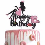 Tort decorat cu un topper din carton cu sclipici negru ce afiseaza mesajul Happy 18th Birthday, acompaniat de silueta unei fete in rochie roz cu sclipici, o coronita, un ruj si buze rosii