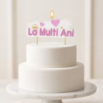 Lumanare aprinsa cu mesajul La Multi Ani roz asezata in varful unui tort alb etajat cu un design minimalist si rafinat