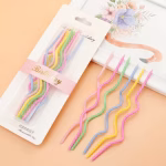 Ambalajul elegant al setului de lumanari spiralate pastelate prezentat alaturi de un tablou floral decorativ