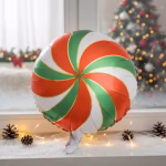 Balon rotund din folie metalizată, ilustrând o bomboană tip acadea cu un model spiralat festiv în culorile roșu, verde și alb, separate de linii aurii subțiri