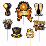 Set de 7 toppere pentru tort din carton, ilustrând elemente festive de Revelion în culorile negru și auriu: un cadou cu baloane, o frapieră plină cu șampanie, artificii cu anul 2027 pe o panglică, un joben elegant, un ceas care indică miezul nopții, pahare de șampanie și mesajul Happy New Year