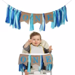Banner Ghirlanda ONE Prima Aniversare Banner decorativ pentru prima aniversare baietel, format din 3 steaguri rustice cu textul ONE si panglici bicolore in nuante de albastru, lungime 90 cm.