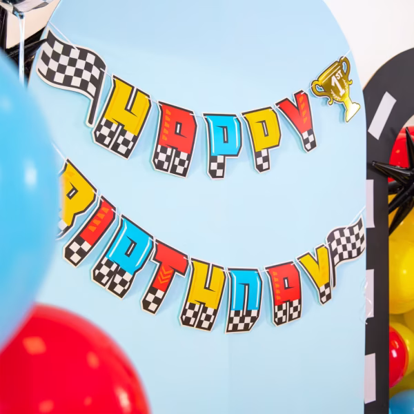Banner Happy Birthday Tematica Racing Masini de Curse 220x17 cm Banner Happy Birthday din carton cu tematica racing masini de curse, litere colorate cu baza in carouri alb-negru, include 2 steaguri de finish si un trofeu de campion, 220x17 cm.