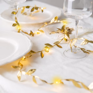 Ghirlanda LED Frunze Aurii Premium 300 cm Ghirlanda luminoasa cu 30 de beculete LED si frunze aurii metalizate pe fir flexibil, lungime 3 metri, functionare pe baterii pentru aranjamente mese festive.