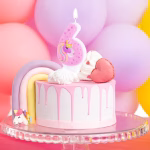 Lumanare Tort Unicorn Cifra 6 Lumanare cifra 6 roz cu inimioare si unicorn aprinsa pe un tort aniversar cu baloane