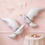 Balon Folie Porumbel Alb Elegant, cu Detalii Aurii, 100x78 cm Balon din folie gigant in forma de porumbel alb elegant, cu detalii aurii si ochi inchisi visatori, plutind intr-un decor floral rafinat de nunta sau botez.