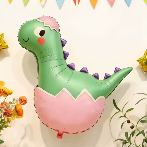 Balon Folie Pui de Dinozaur in Ou, Decor Petrecere, 64x70 cm Balon din folie gigant in forma de pui de dinozaur verde simpatic, cu tepi mov, iesind dintr-un ou roz pastel, ideal pentru decor petreceri copii.