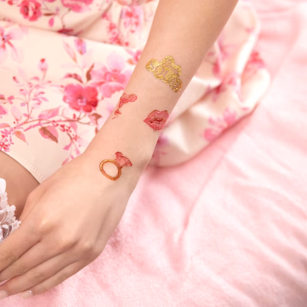 Set 19 Tatuaje Temporare Bride to Be, Roz Auriu si Negru Colectie de 19 modele de tatuaje temporare pentru petrecerea burlacitelor, incluzand inele cu diamant, buze, ochelari, pahare de cocktail si mesaje bride squad in culorile roz, auriu si negru.