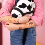Set 21 Tatuaje Temporare Copii, Tematica Cai si Echitatie Bratul unui copil avand aplicate tatuaje temporare cu caluti si mesajul I love horses, in timp ce deseneaza si se distreaza la o petrecere.