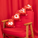 Ghirlanda din balon folie rosie formata din 4 inimi unite, cu textul LOVE imprimat cu litere albe groase.