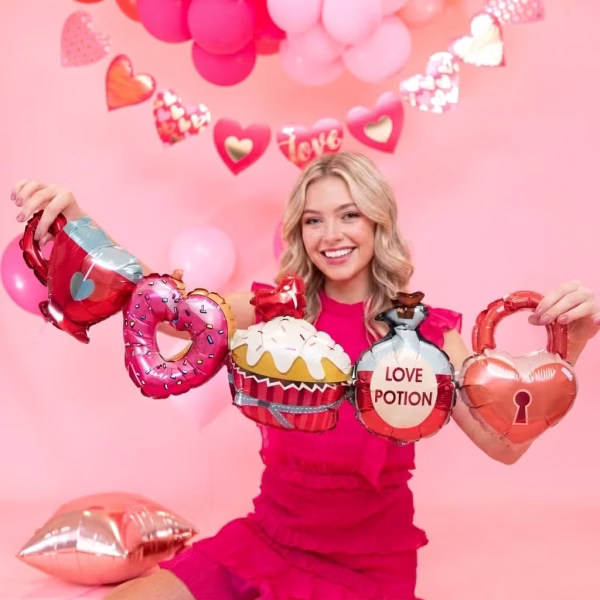 ghirlanda baloane sweet love O tanara zambitoare imbracata in roz, tinand in maini o ghirlanda din baloane folie cu forme de ceasca, gogoasa inima, briosa, licoarea dragostei si lacat.