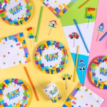 Aranjament festiv pentru o petrecere cu tematica piese Lego, incluzand servetele Block Party asortate perfect cu farfurii, pahare si paie colorate.