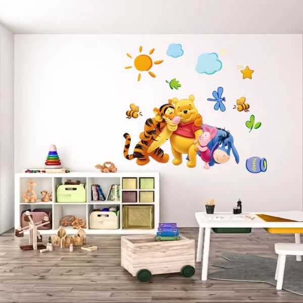 Sticker perete Winnie Sticker decorativ de perete ilustrandu-i pe Winnie the Pooh, Tigrila, Purcelus si Aiurel imbratisati, alaturi de soare, nori si albine, aplicat pe peretele unei camere de joaca luminoase.
