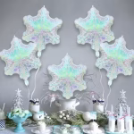 Decor festiv de iarna pentru Candy Bar, cu dulciuri tematice si baloane din folie sub forma de fulgi de zapada plutind pe fundal.