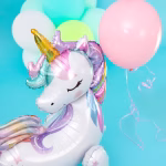 Detaliu al capului unui balon folie unicorn airwalker cu corn auriu si coama pastelata pe un fundal cu baloane.