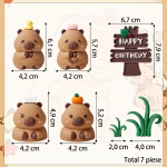 Schemă detaliată cu dimensiunile celor 7 piese din set: Capibara cu rață 6.1 cm, cu floare 5.7 cm, cu portocală 5.2 cm, cu prosopel 4.9 cm, panou Happy Birthday 7.9x6.7 cm și tufe de iarbă de 4 cm și 2 cm lățime.