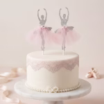 Set 2 Toppere Tort Balerine Argintii Tort alb elegant, decorat cu o bordură din dantelă fondantă și perle, având în vârf un set de 2 toppere sub formă de balerine argintii cu sclipici și fustițe din tul roz.