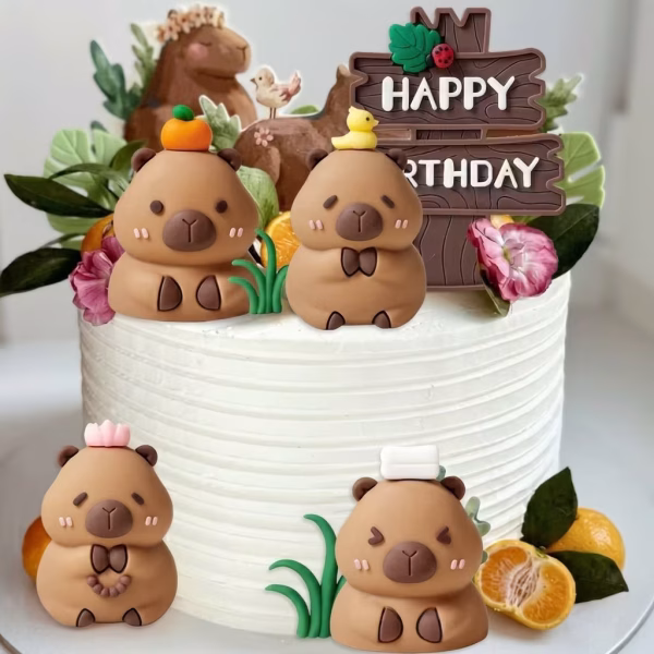 Set 7 Toppere Tort 3D Capibara Tort alb decorat cu un set de 7 toppere 3D simpatice: patru figurine Capibara (cu rățușcă, portocală, prosopel și floare), alături de tufe de iarbă și un panou Happy Birthday din plastic.