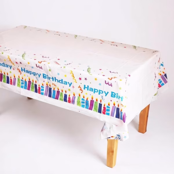 Fata De Masa Party Happy Birthday Fata de masa dreptunghiulara din plastic alb decorata pe margine cu lumanari colorate stelute confetti si textul albastru Happy Birthday.