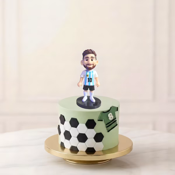 Figurină 3D pentru tort Lionel Messi în echipamentul naționalei Argentinei, plasată pe un tort cu tematică fotbalistică.