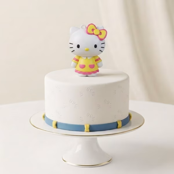 Figurină 3D Hello Kitty pentru tort, îmbrăcată într-o rochiță galbenă cu buzunare roz.