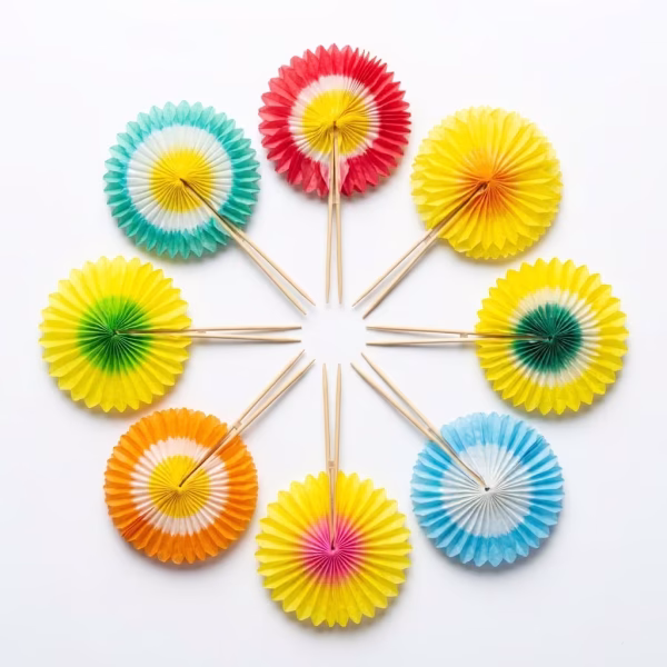 Set 6 Ornamente tip Floare Ornamente decorative tip floare (rozetă/evantai) din hârtie multicoloră în nuanțe vibrante, fixate pe bețișoare subțiri din lemn, așezate în cerc pe un fundal alb.