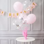Suport Greutate Baloane Roz cu Betisoare Aranjament festiv pe o masa rotunda alba, folosind un suport cu greutate pentru baloane roz, decorat cu 5 baloane asortate in nuante de roz pastel si transparente cu confetti.
