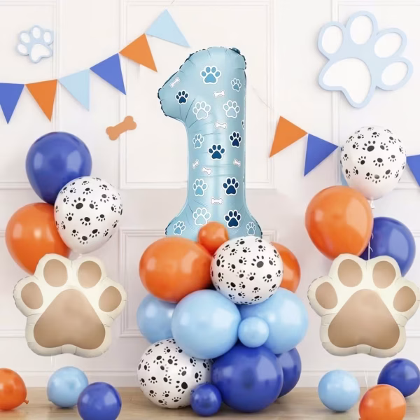 Aranjament festiv pentru aniversarea de 1 an cu o cifra albastra decorata cu labute asezata pe o baza din baloane albastre portocalii si albe cu imprimeu canin