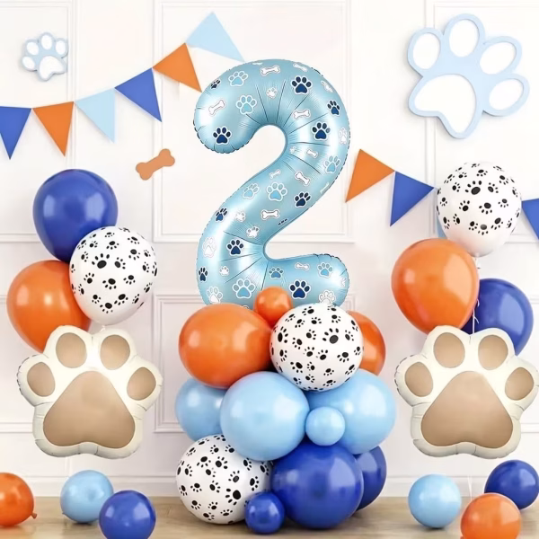 Aranjament festiv pentru aniversarea de 2 ani cu o cifra albastra decorata cu labute asezata pe o baza din baloane albastre portocalii si albe cu imprimeu canin