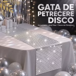 Cina festiva eleganta cu pahare de cristal lumanari aprinse si un centru de masa sustinut de o traversa argintie.