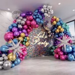 Decor de petrecere cu o arcada organica din baloane latex chrome in nuante vibrante de auriu argintiu albastru roz mov si verde accesorizata cu sfere disco si stele 4D argintii