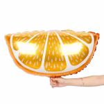 O mana tinand un balon din folie in forma de felie de portocala stralucitoare evidentiind dimensiunea generoasa a produsului