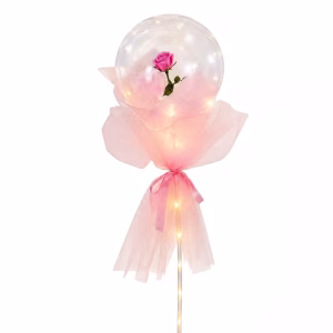 Balon Transparent Sferic Iluminat Cu Led Uri Ce Contine Un Trandafir Roz In Interior Fiind Decorat Cu Tulle Si Panglica Roz Pe Un Suport De Expunere