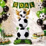 Balon Folie Airwalker Fotbal 92x40 cm Balon airwalker cu tematica fotbal plasat in fata unui perete decorat cu banner goal si baloane verzi si negre langa o masa cu briose