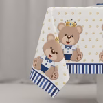 Fata De Masa Tematica Ursuleti Detaliu cu fata de masa din plastic ilustrand un ursulet simpatic cu papion albastru si coroana aurie pe un fundal alb decorat cu coronite