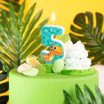 Lumanare de tort in forma cifrei 5 verde cu solzi decorata cu un dinozaur T-Rex portocaliu zambitor.